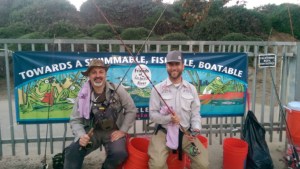SITTIN' PRETTY: Greg Madrigal of Sierra Nets, left, and Stan Adermann sit among orange collection buckets. Madrigal landed one of the three carp caught during the event.